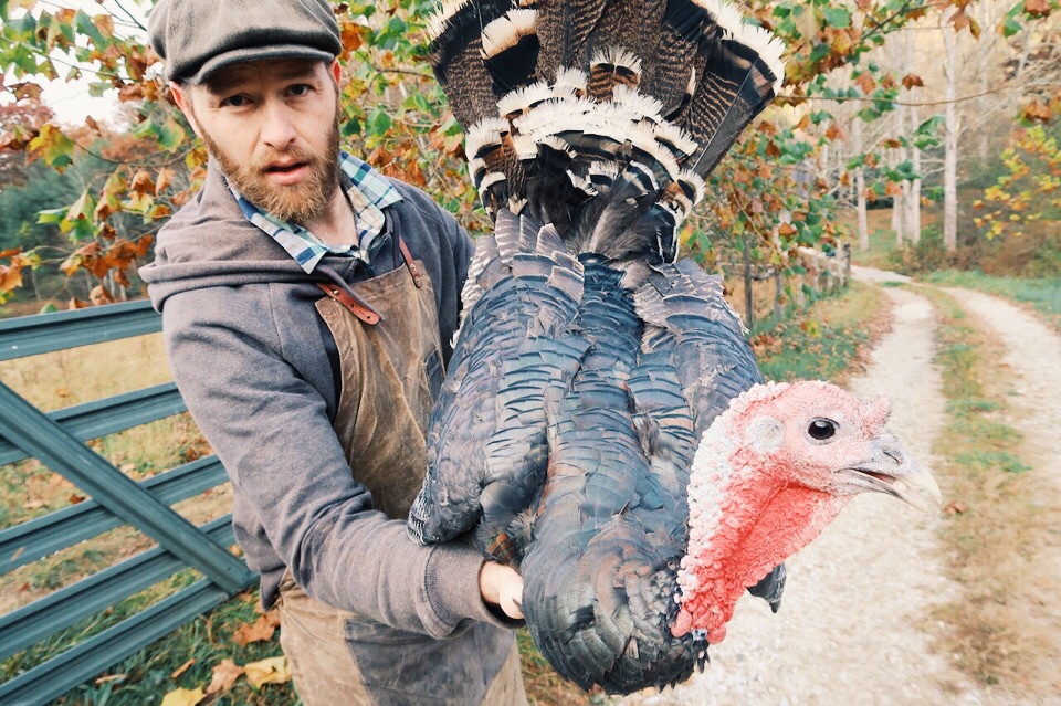 A man holding up a large turkey.