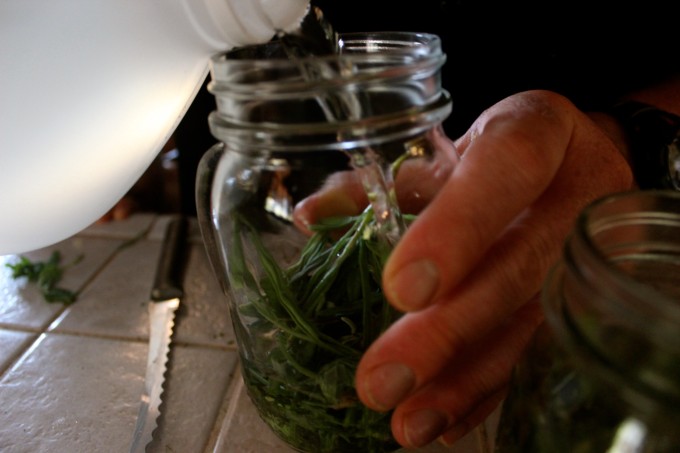 A jar being filled with vinegar.