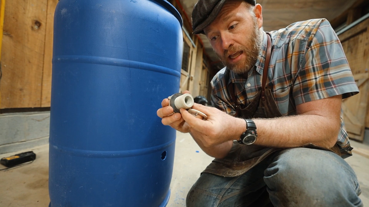 Making a DIY pig waterer with a blue 55 gallon barrel.