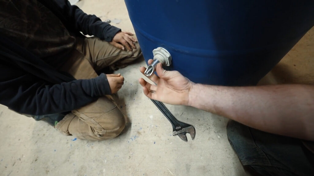 Making a DIY pig waterer with a blue 55 gallon barrel.