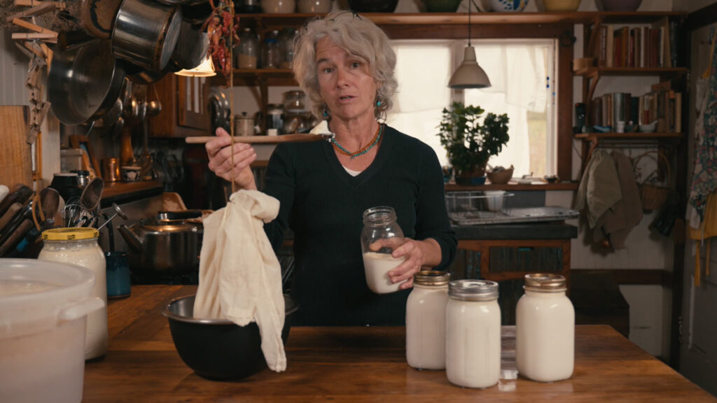 A woman holding up a spoonful of yogurt.